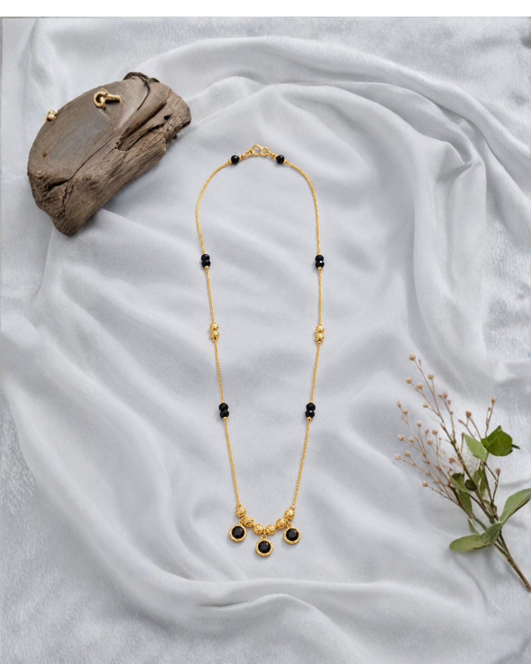 Black gemstone mangalsutra necklace with three gold-tone charms
